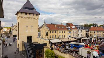 A historic building with a tower, a covered market area, and a river.
