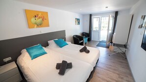 Une chambre d’hôtel avec deux lits, un bureau, une chaise et une table à manger.