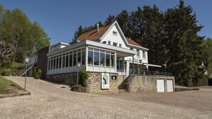 Un bâtiment à deux étages, doté d’une façade en pierre, de grandes fenêtres et d’une enseigne indiquant qu’il s’agit d’un hôtel.