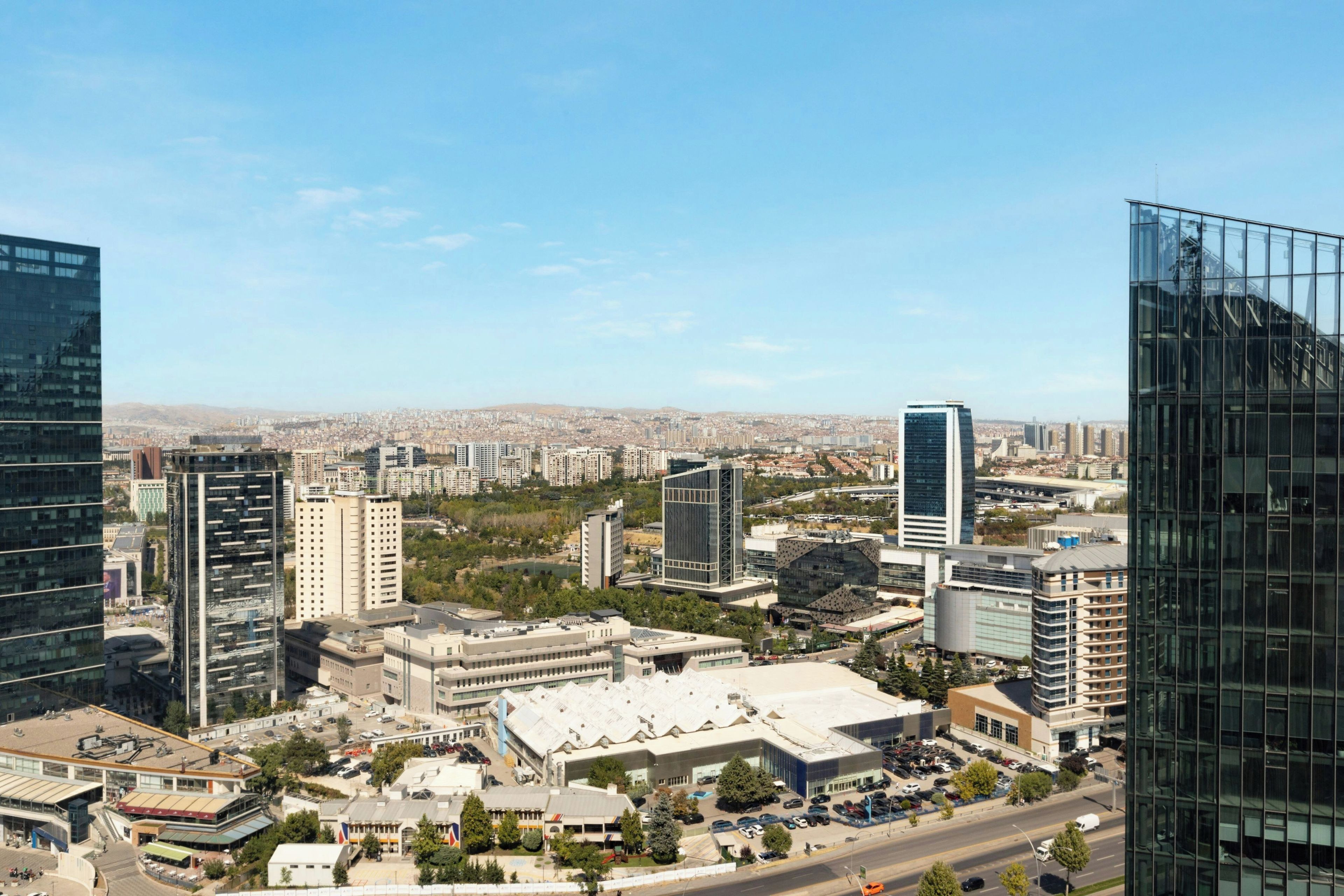 A cityscape with modern buildings, a mix of high-rise and low-rise structures, and a clear sky.