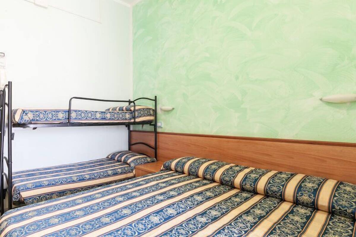 A room with bunk beds and a green patterned wall.