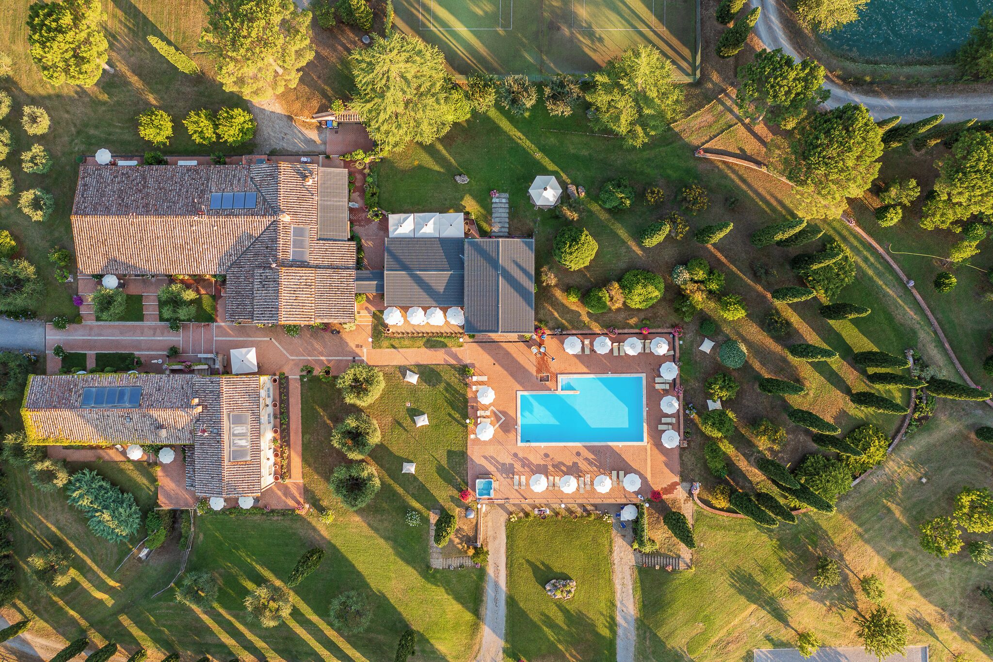 Vista aerea di una proprietà con piscina, numerosi patii e un ampio giardino.
