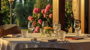 A table set for a meal with clear glassware, a folded napkin, and a small vase with yellow flowers.