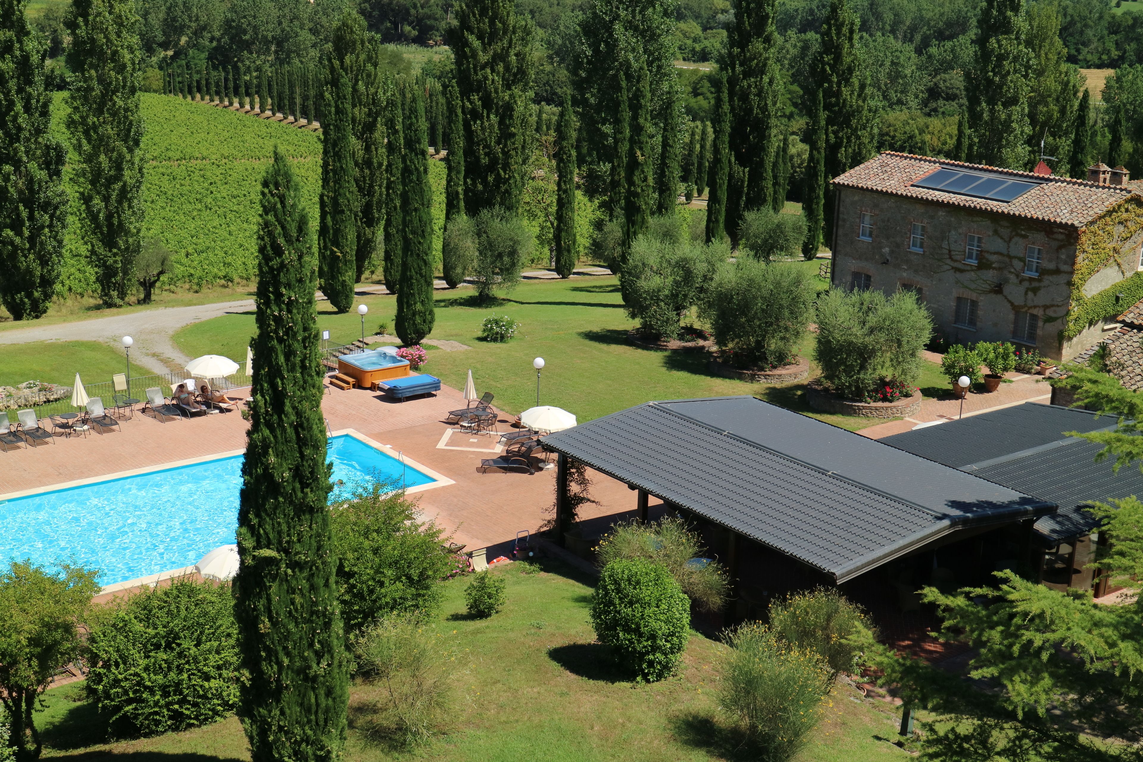 A villa with a swimming pool, outdoor seating, and a garden.