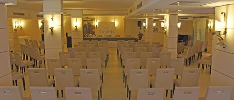 A hotel lobby with rows of seating and a reception area in the center.