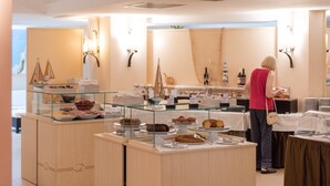 A buffet area with various food items and a person standing near the counter.