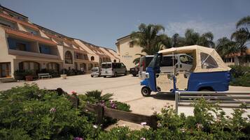 A building with a sign reading "TROPIS" and a blue and beige vehicle parked in front.