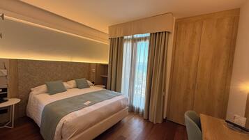 Una camera d'albergo con un letto grande, una scrivania e una sedia.