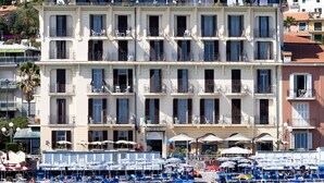 A multi-story hotel with balconies, a beachside location, and a view of the sea. - Hotel Parigi & Spa (Bordighera)