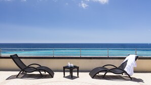 A balcony with two lounge chairs and a small table, overlooking a clear blue sea and a distant shoreline. - Hotel Parigi & Spa (Bordighera)