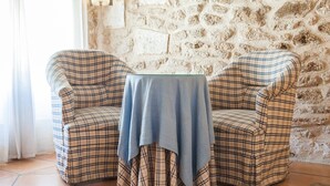 A corner seating area with two plaid chairs and a small table covered with a blue cloth. - Can Simo Turismo de Interior (Alcúdia)