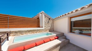 A swimming pool with steps and red cushions, a stone wall, and a wooden fence. - Can Simo Turismo de Interior (Alcúdia)