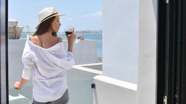 A balcony with a glass railing overlooking a beach.