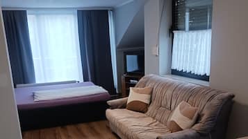 Uma sala de estar moderna com um sofá, uma mesinha e uma cama.
