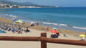 Una playa con sombrillas y gente.
