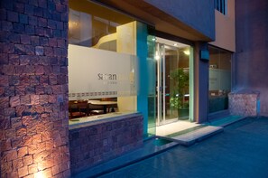 Un edificio moderno con entrada de vidrio, fachada de piedra y un cartel que dice "Savanpan".