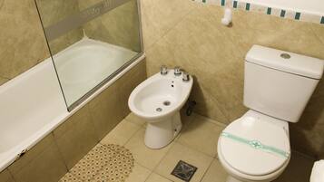 A bathroom with a bathtub, a bidet, and a toilet.