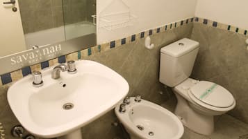 Un baño con un lavamanos grande, un bidé y un inodoro.