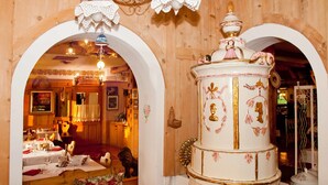 Ein Essbereich mit Holzvertäfelung, einer weißen Torte mit goldenen Verzierungen und einem Chandelier.
