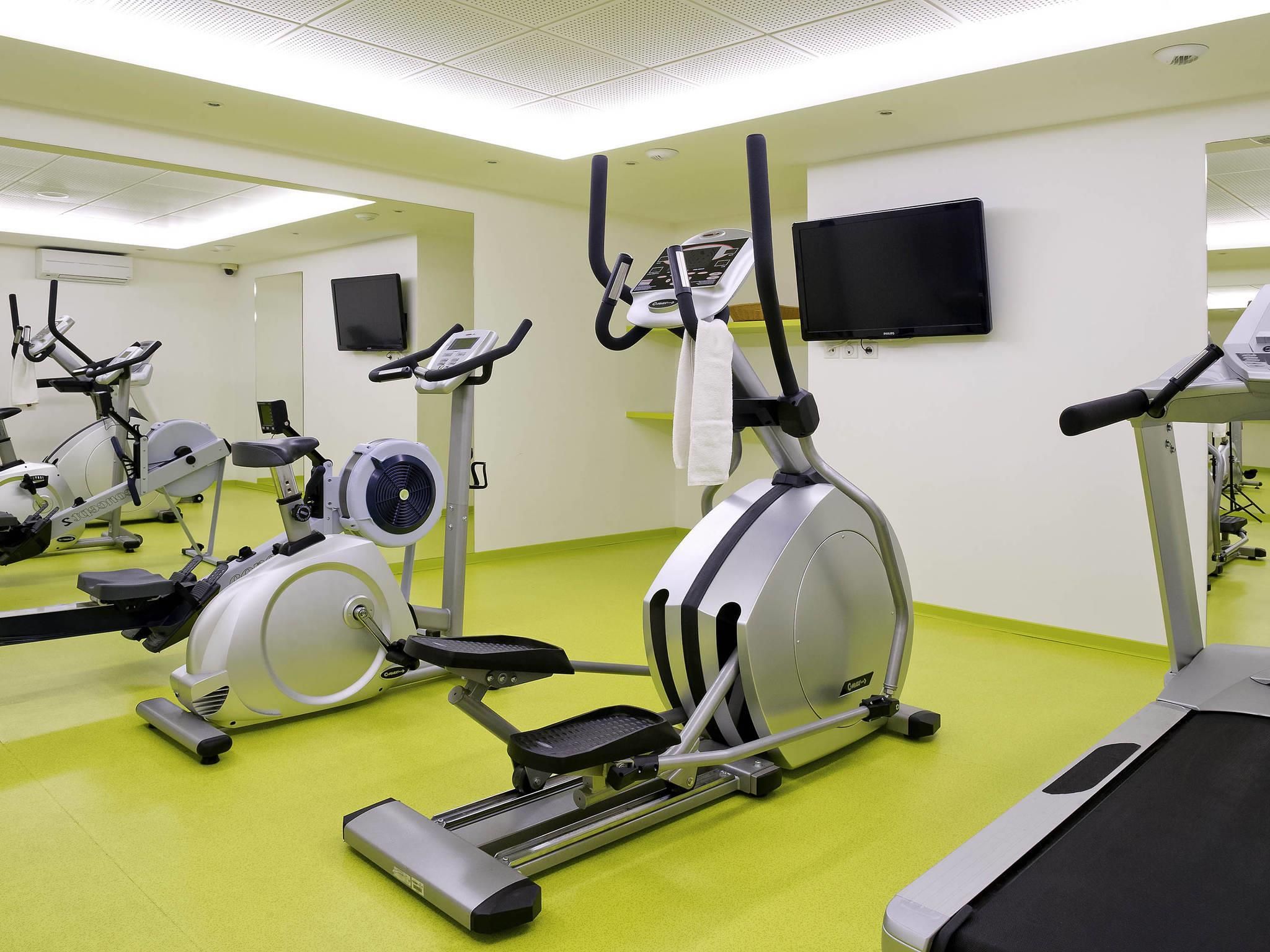 A gym with stationary bikes, treadmills, and exercise equipment.