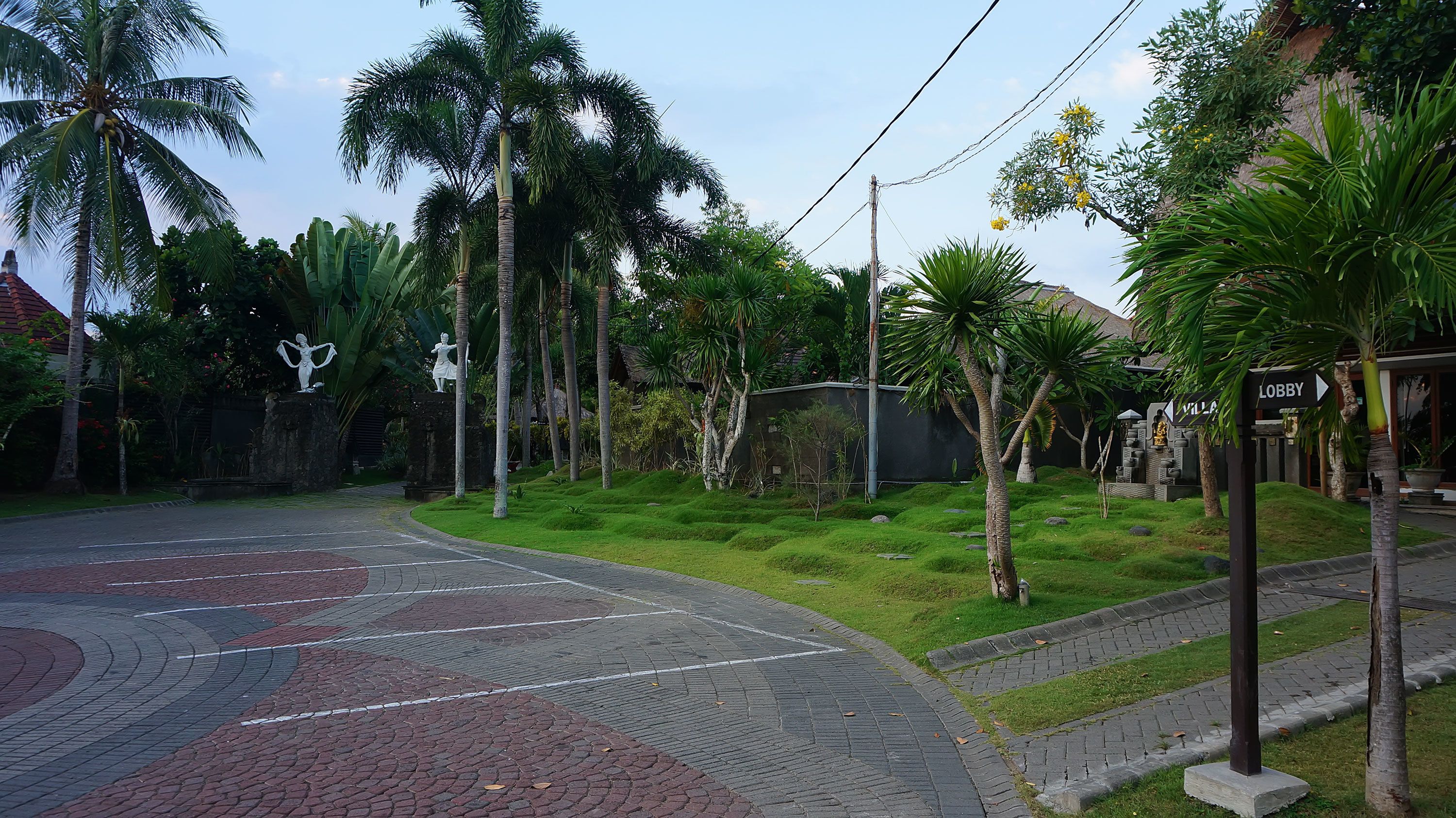 A paved pathway leading to a building with a sign indicating a lobby.