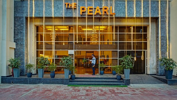 Entrada de un hotel con un gran letrero que dice "THE PEARL".