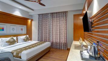 A hotel room with a bed, a bedside table with a coffee maker, and a ceiling fan.