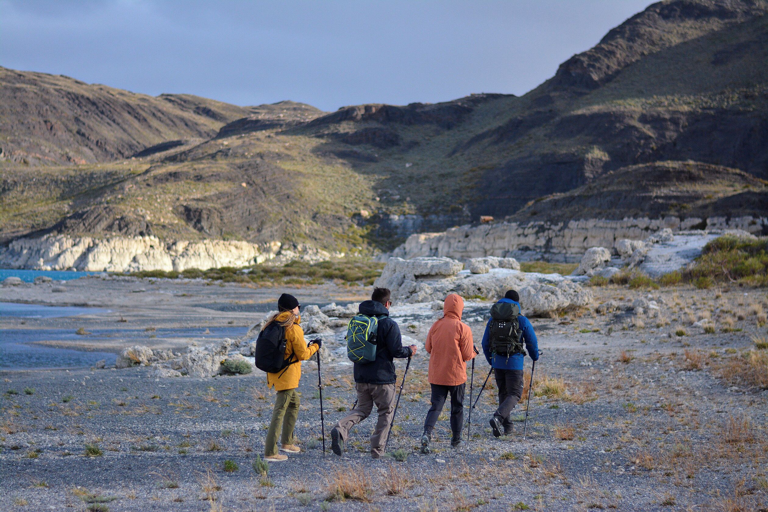 Eine Gruppe Wanderer auf felsigem Gelände, im Hintergrund Berge.