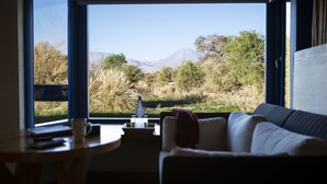 Habitación con un amplio ventanal que ofrece vistas a una montaña y la vegetación circundante.
