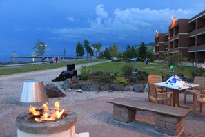 A patio area with a fire pit, outdoor seating, and a view of the sea. - The Inn on Lake Superior (Duluth)