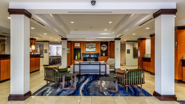 A hotel lobby with a reception desk, seating area, and a fireplace. - Fairfield Inn & Suites by Marriott Millville Vineland (Millville)