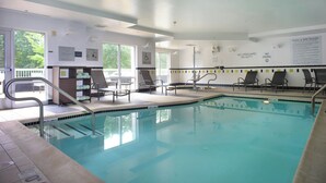 A swimming pool with a lifeguard station, lounge chairs, and clear pool rules posted on the walls. - Fairfield Inn & Suites by Marriott Millville Vineland (Millville)