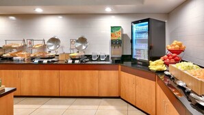 A buffet setup with various food items and a refrigerator. - Fairfield Inn & Suites by Marriott Millville Vineland (Millville)