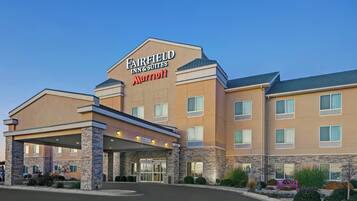 A Fairfield Inn & Suites Marriott hotel with a covered entrance, stone facade, and multiple windows.