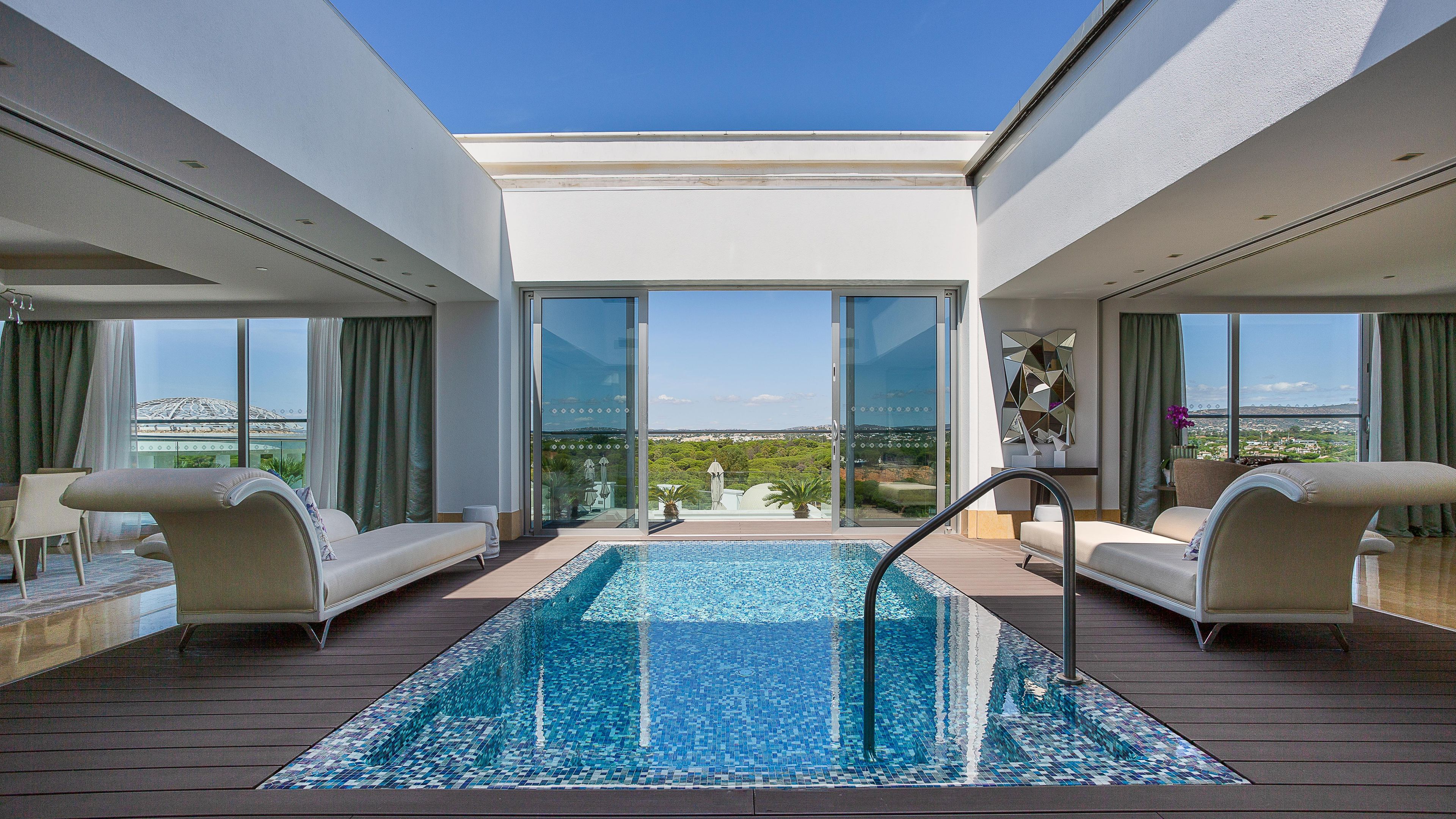Un área de piscina moderna en la azotea con una vista despejada del paisaje urbano.