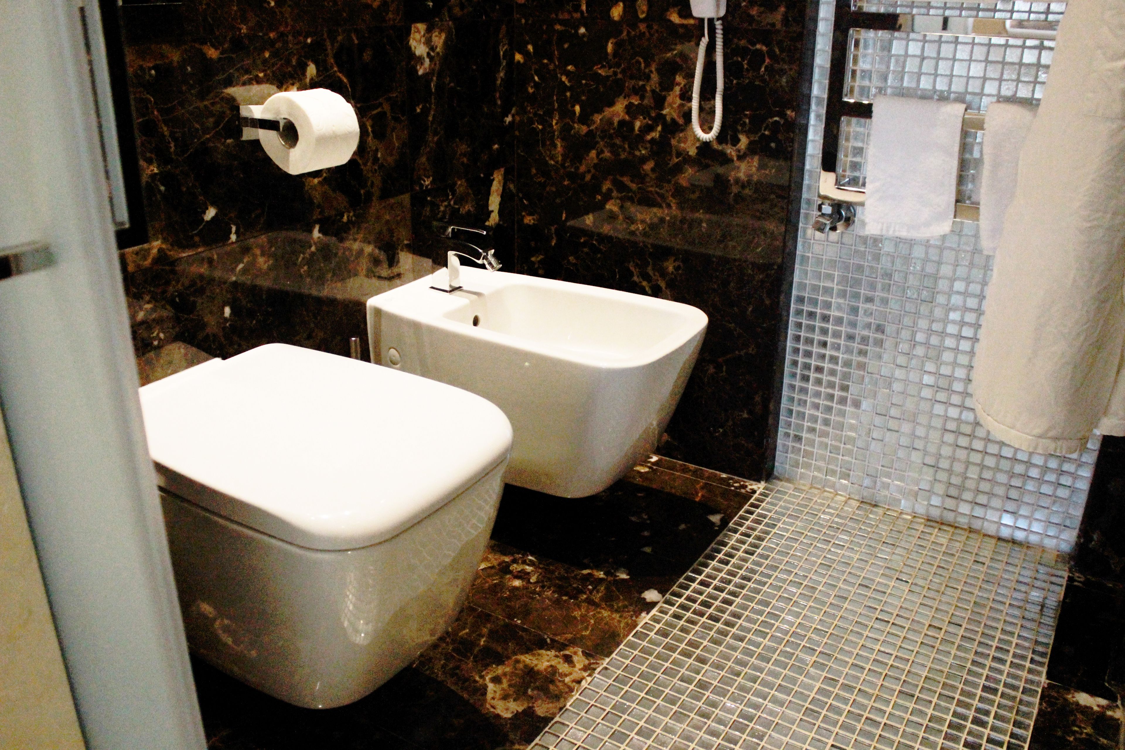 Un baño con inodoro, bidé y zona de ducha.