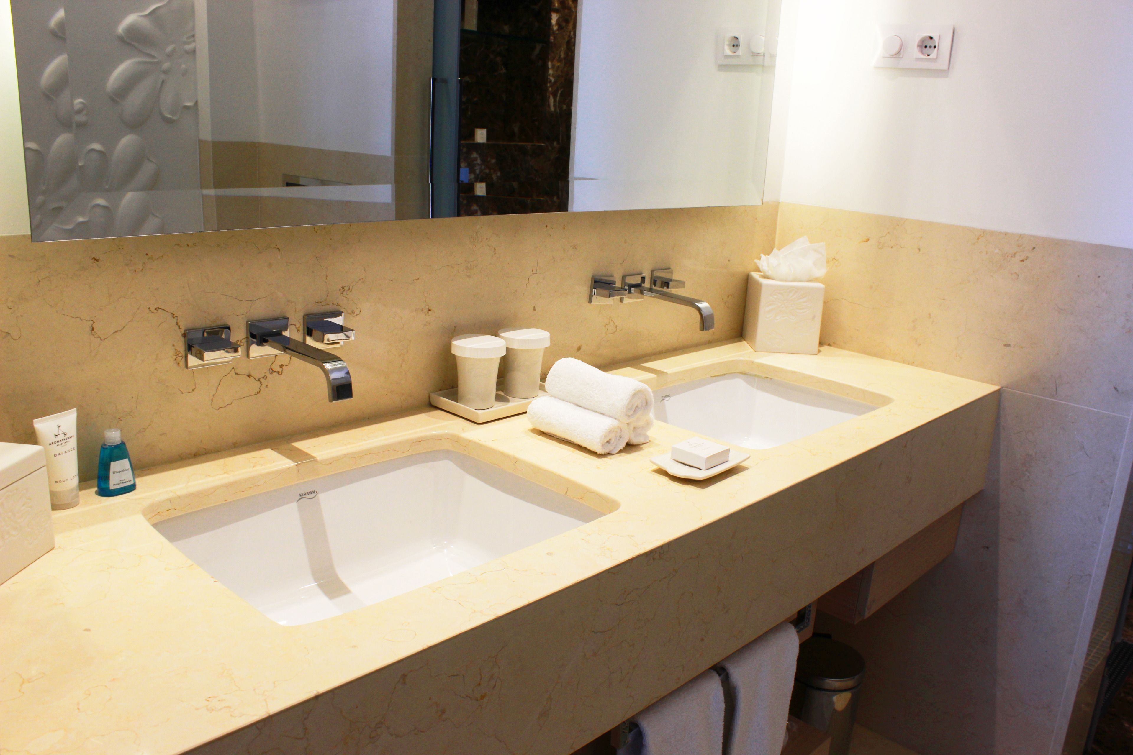 Une salle de bain avec deux lavabos, un grand miroir et un porte-serviettes.