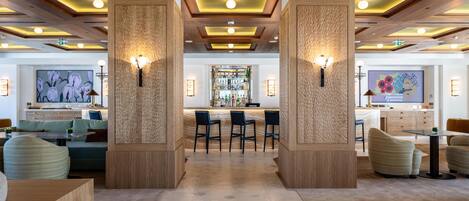 A modern bar area with wooden accents, bar stools, and a central bar counter.