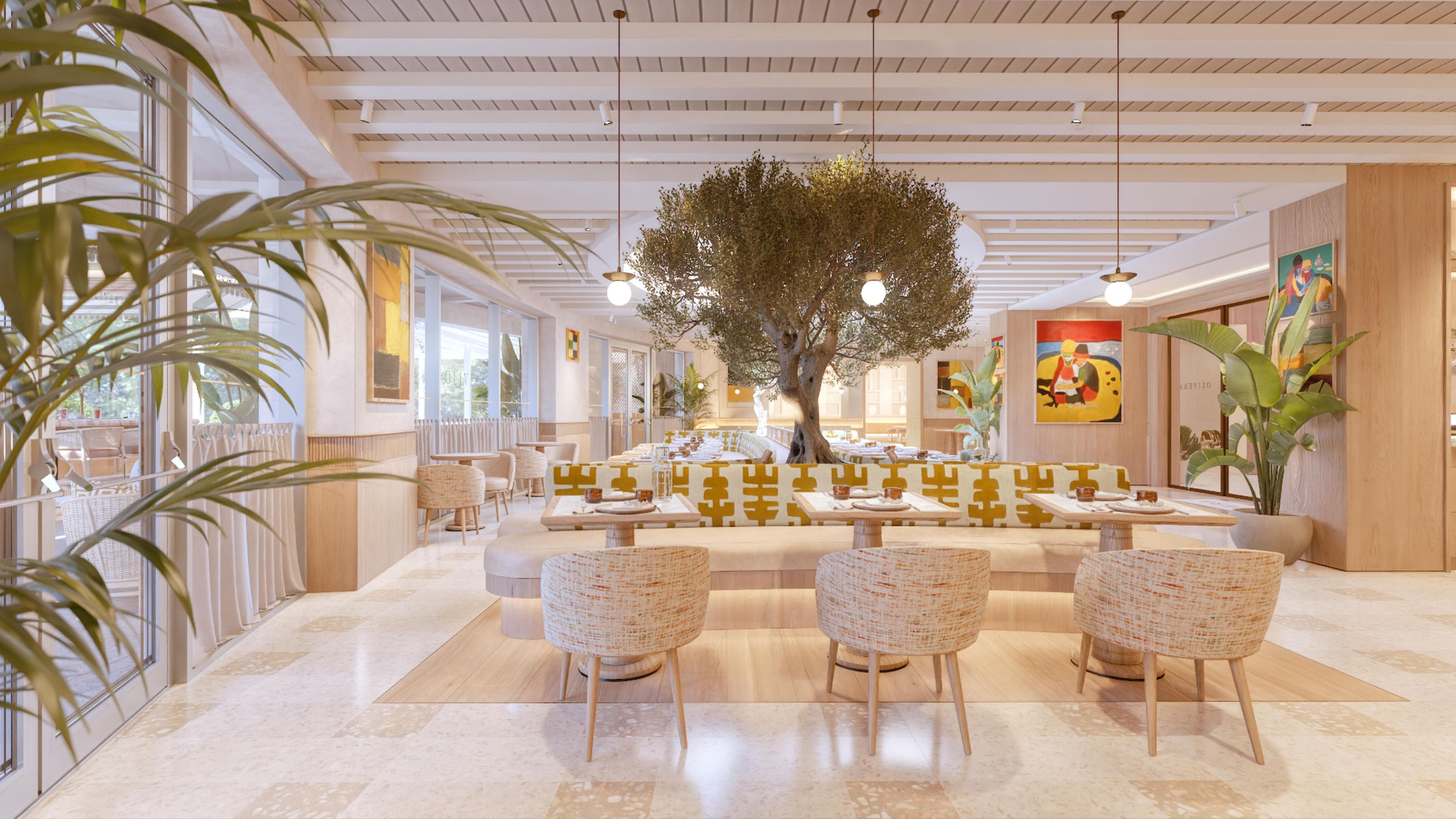 A spacious indoor area with a central seating arrangement, large windows, and a tree centerpiece.