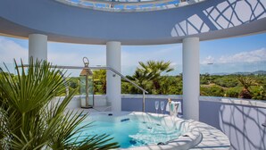 A hot tub on a balcony with a clear view of the landscape.