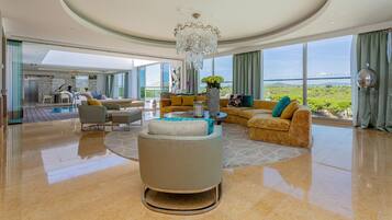 A spacious living area with a large window, a chandelier, and a view of the outdoors.