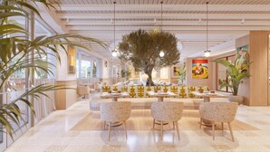 A spacious indoor area with a central seating arrangement, large windows, and a tree centerpiece.