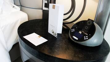 A black round table with a JBL speaker, a card, and a small booklet.