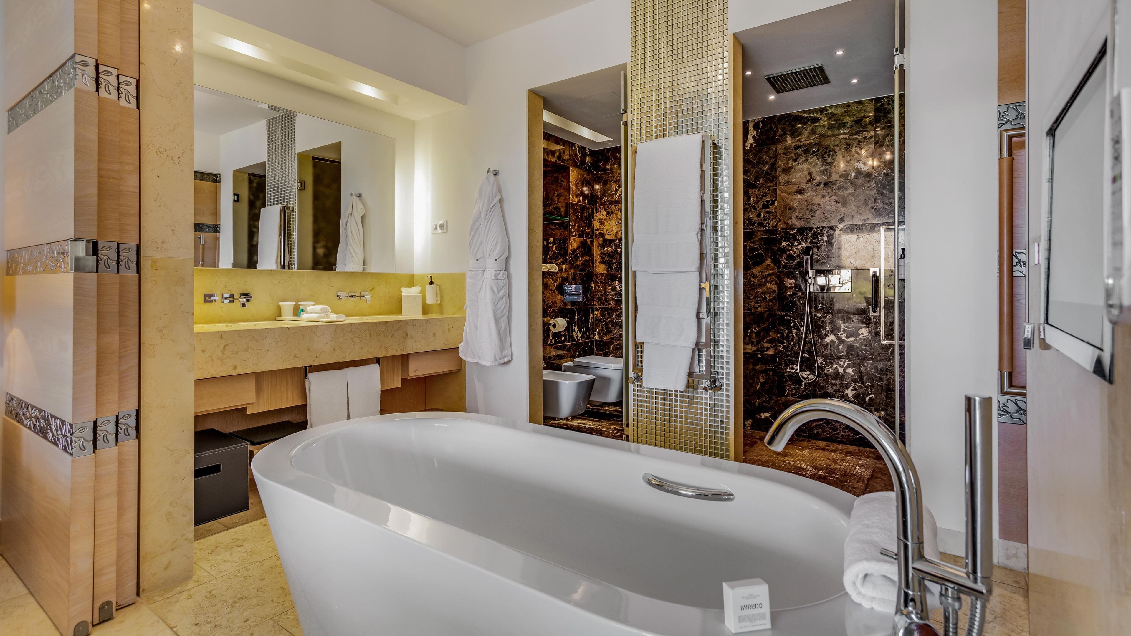 Un baño moderno con una bañera independiente, un tocador con espejo y una zona de ducha con cabina de vidrio.