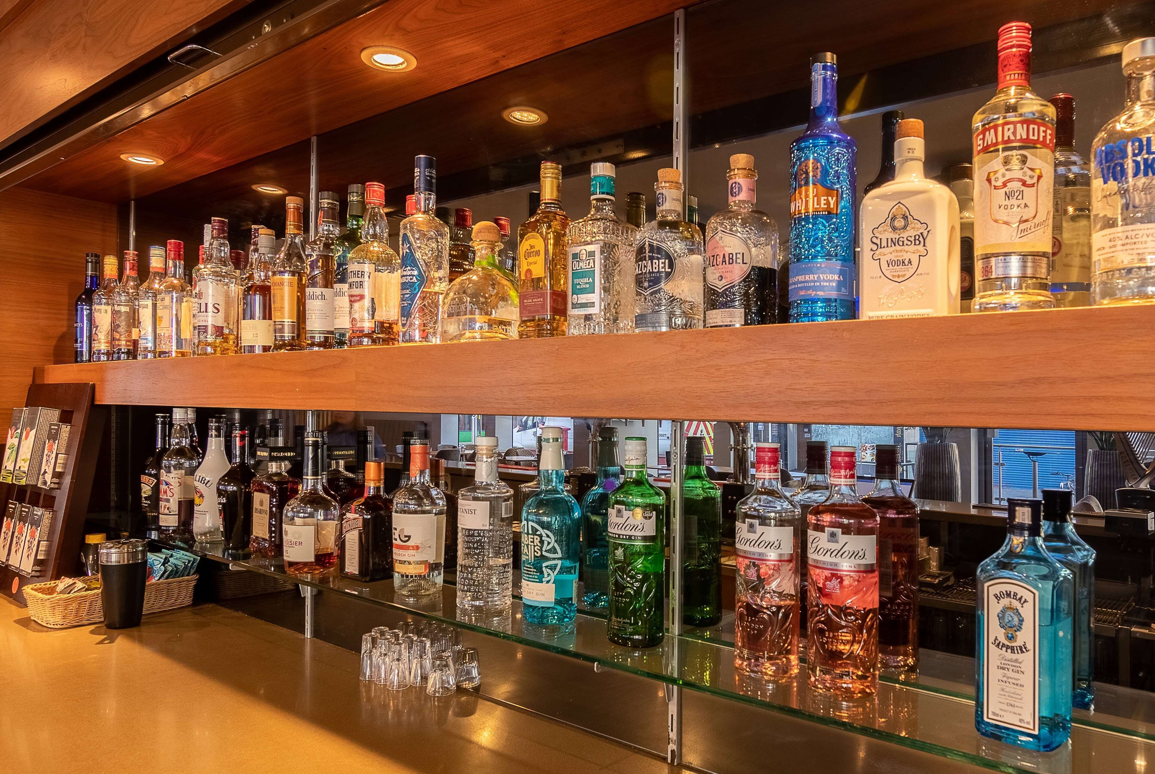 A bar area with multiple shelves stocked with various bottles of liquor.