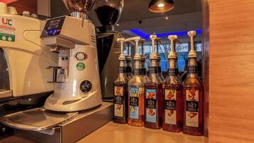 Une machine à café et des bouteilles de sirop de la marque 183 sont posées sur un comptoir.