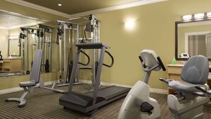A hotel room with a treadmill, exercise bike, and a mirror. - Days Inn by Wyndham High Level (High Level)