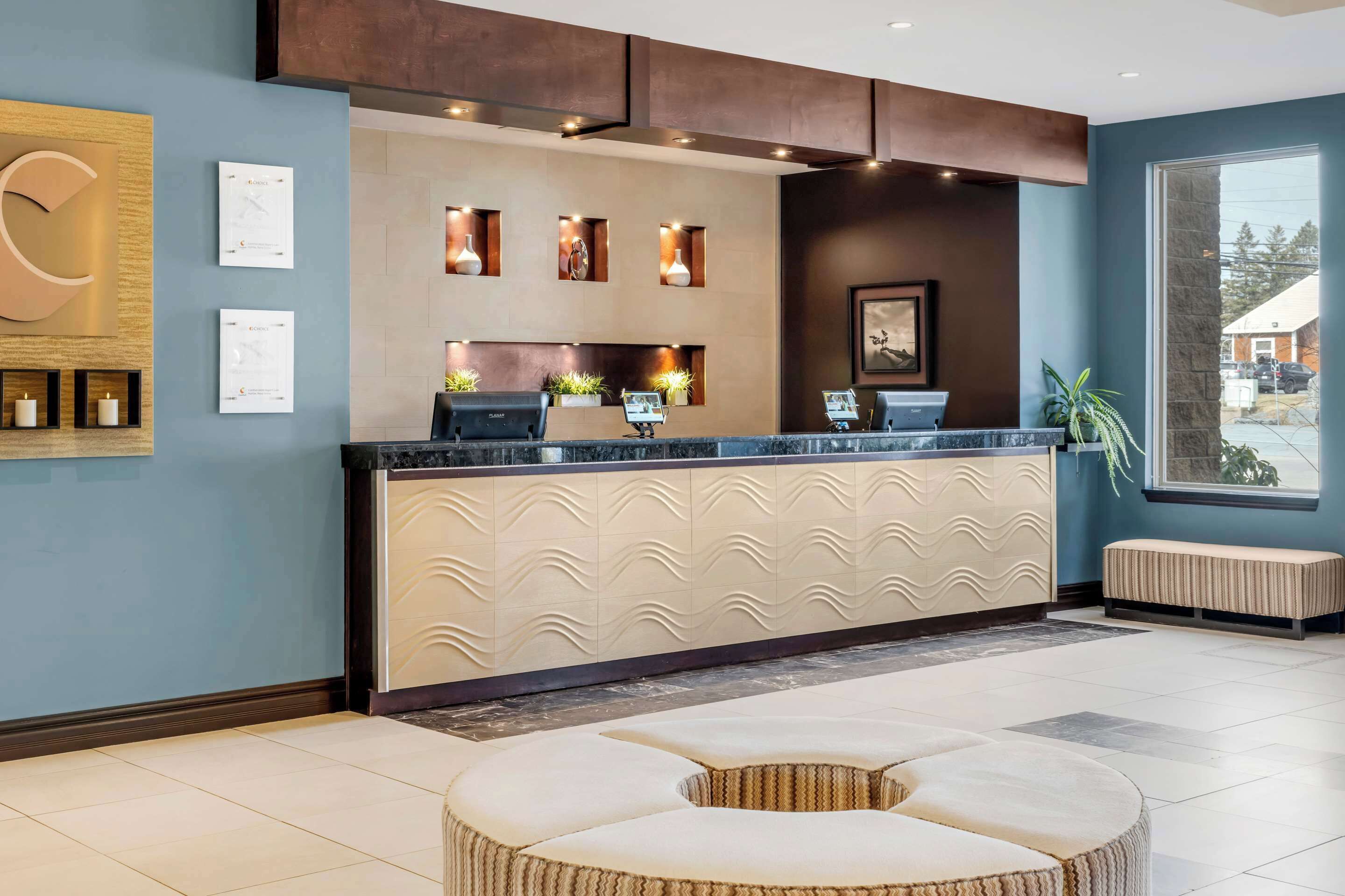 A reception area with a modern design, featuring a counter, seating, and decorative elements.