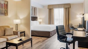Una habitación de hotel con una cama, un sofá, un escritorio y una silla.