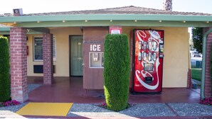 Ein Gebäude mit einer Coca-Cola-Getränkeautomaten, einem Eisbereiter und einer Tür mit der Aufschrift 'ICE'.